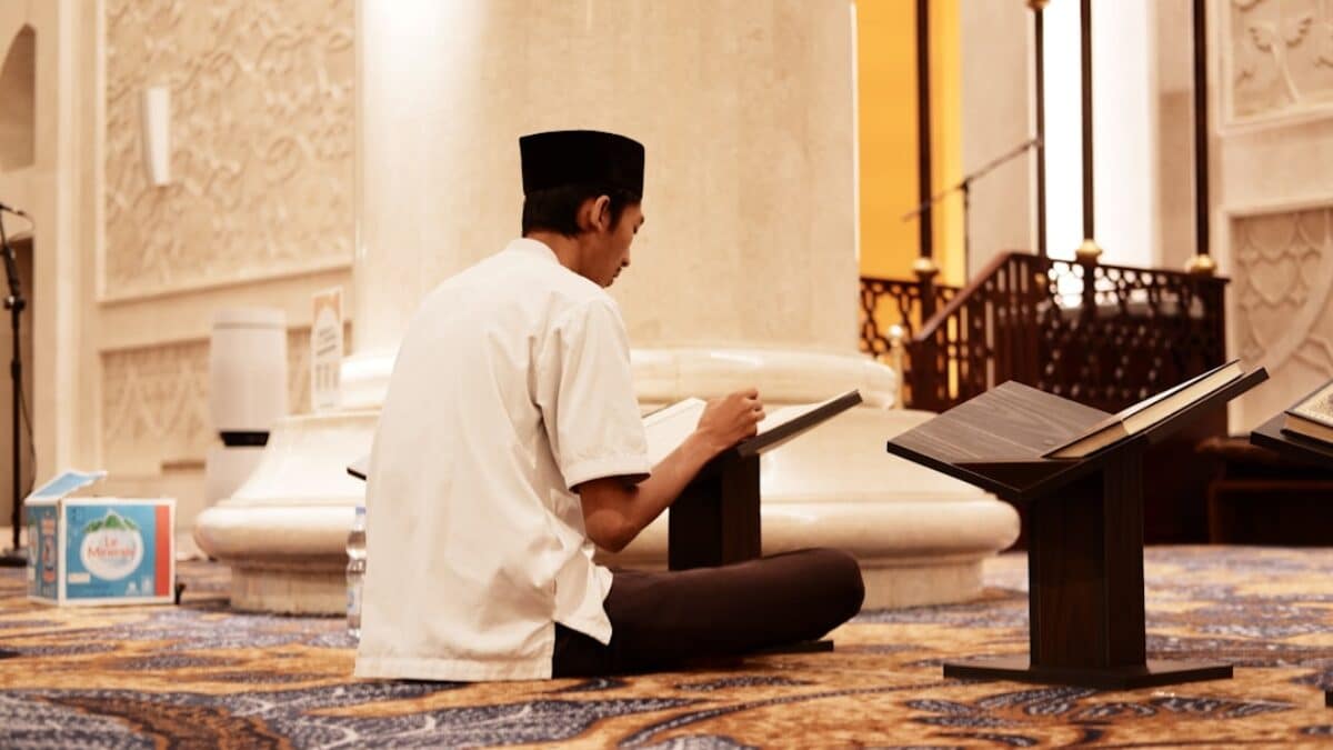 a man sitting on the floor reading a book
